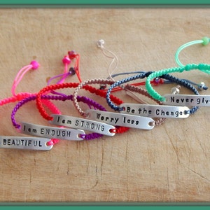 May include: A set of eight colourful friendship bracelets with adjustable closures. Each bracelet features a silver charm with an inspirational message, including "I am Beautiful", "I am Enough", "I am Strong", "Worry Less", "Be the Change", and "Never give up".