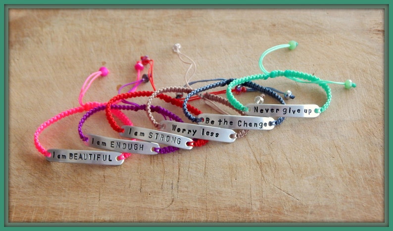 May include: A set of eight colourful friendship bracelets with adjustable closures. Each bracelet features a silver charm with an inspirational message, including "I am Beautiful", "I am Enough", "I am Strong", "Worry Less", "Be the Change", and "Never give up".