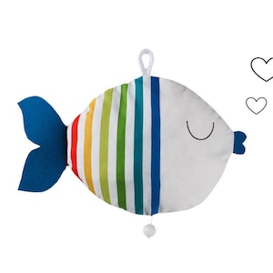 May include: A plush rainbow striped fish toy with a blue tail fin. The fish has a white body with a black smiling mouth and a black heart above it.