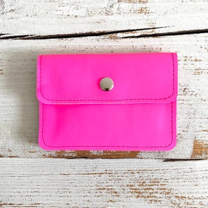 Cartera rosa neón con 5 compartimentos fabricada en piel.