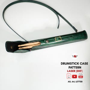 May include: A dark green leather drumstick case with a long shoulder strap, a gold-toned buckle, and a snap closure. Two wooden drumsticks are visible inside the open case. Text reads: V&P DRUMSTICK CASE PATTERN LASER (DXF) PDF A0, A4, LETTER.