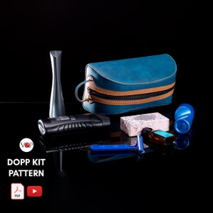 Könnte beinhalten: Eine blaue Leder-Toilette-Tasche mit braunen Lederverzierungen und einem Reißverschluss. Die Tasche ist gefüllt mit Toilettenartikeln, darunter eine Flasche Aftershave, eine Seife und ein Rasierer. Das Bild enthält auch den Text "Dopp Kit Pattern" und ein Logo mit den Buchstaben "V&P".