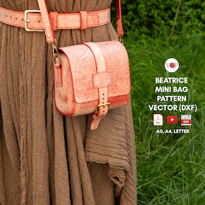 May include: A small, coral-colored leather crossbody bag with a matching belt. The bag has a rectangular shape with a flap closure and a buckle. The belt is worn around a brown dress. The image also includes the text "BEATRICE MINI BAG PATTERN VECTOR (DXF)".