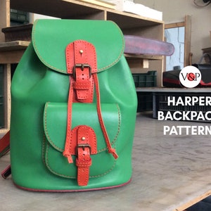 May include: A green leather backpack with orange leather accents and buckles. The backpack has two front pockets and a drawstring closure. The text "HARPER BACKPACK PATTERN" is visible in the image.
