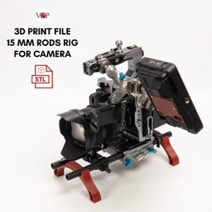 May include: A 3D printed camera rig with 15 mm rods, a monitor, and a camera. The rig is made of black and silver metal and has red accents. The camera is a black DSLR with a lens attached. The monitor is a black and red screen with a white display. The rig is mounted on a tripod with red legs. The image includes the text "3D PRINT FILE 15 MM RODS RIG FOR CAMERA" and a file icon with the text "STL".