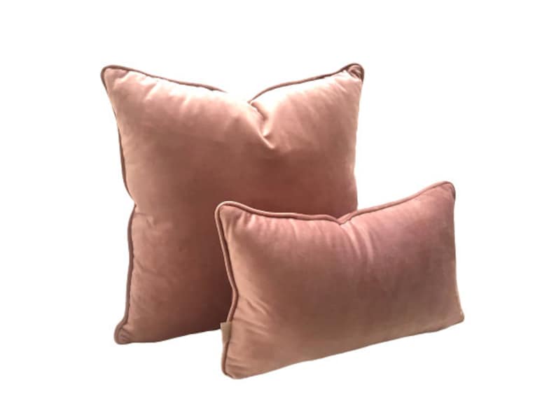May include: Two pink velvet throw pillows, one larger than the other, with a soft, plush texture.