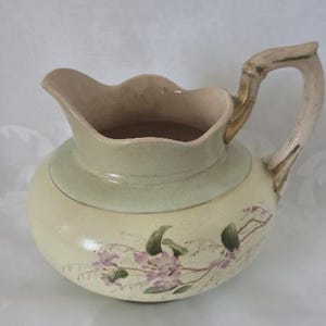 May include: A set of three ceramic mugs with a speckled, matte finish. The mugs are in shades of cream, light gray, and dark gray. Each mug has a simple, minimalist design, perfect for coffee or tea.