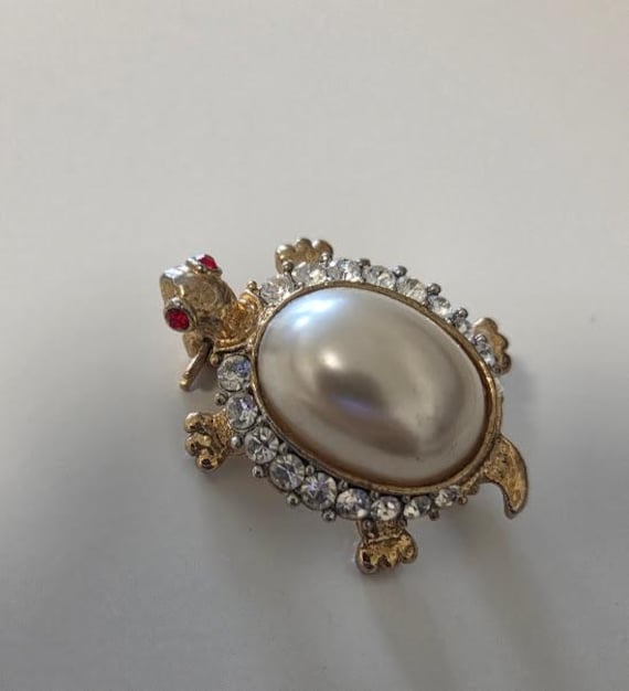 Vintage Gold-Tone Turtle Brooch.  Turtle Brooch with Oval Faux Pearl and Rhinestone Border with Red Rhinestone Eyes.