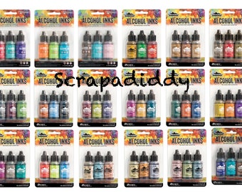 Puede incluir: Un conjunto de 18 tintas de alcohol de varios colores, envasadas en botellas de plástico transparente con etiquetas que dicen "Alcohol Inks". Las botellas están dispuestas en tres filas de seis, con cada fila conteniendo una combinación de colores diferente.