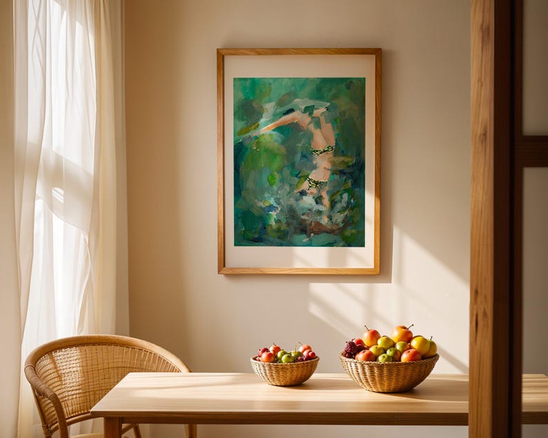 K&ouml;nnte beinhalten: Ein gerahmtes abstraktes Gem&auml;lde einer Person in einer gr&uuml;n-blauen Landschaft. Das Gem&auml;lde h&auml;ngt an einer Wand in einem Raum mit einem Holztisch und Korbst&uuml;hlen. Auf dem Tisch stehen zwei Korbwaren, gef&uuml;llt mit Obst.