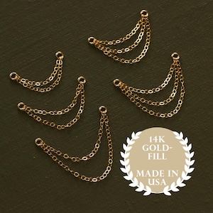 May include: Several gold-filled chain charms with multiple strands, perfect for jewelry making. The charms are arranged on a dark green surface. The image includes a circular emblem that reads "14K Gold-Fill Made in USA."