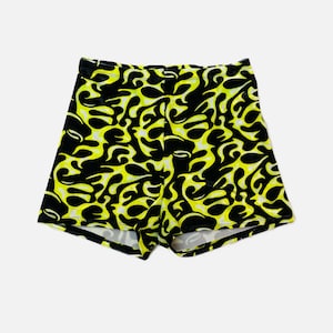 Puede incluir: Shorts negros y amarillos con un patrón de llamas.