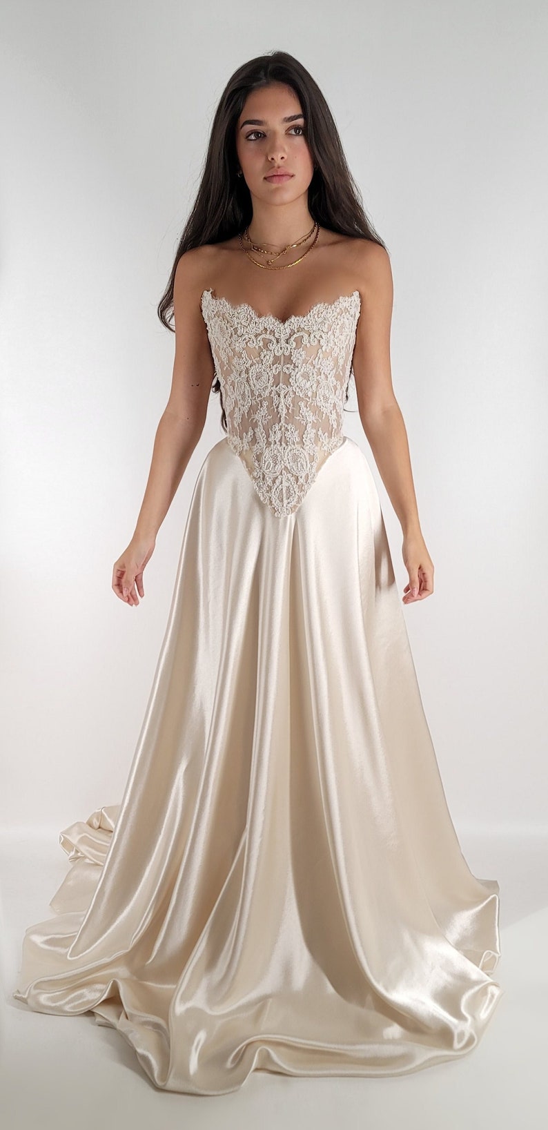 May include: A white strapless wedding dress with a lace bodice and a satin skirt.