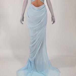 May include: A light blue, strapless gown with a low back and a flowing skirt. The gown is made of a sheer fabric and has a gathered detail at the waist.