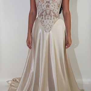 May include: A white strapless wedding dress with a lace bodice and a satin skirt.