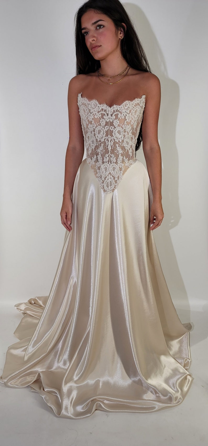 May include: A white strapless wedding dress with a lace bodice and a satin skirt.