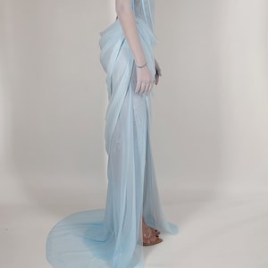 May include: A light blue sheer gown with a fitted bodice and a flowing skirt. The bodice has a beaded embellishment.