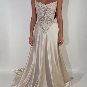 May include: A white strapless wedding dress with a lace bodice and a satin skirt.