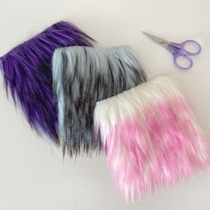 May include: Three pieces of faux fur fabric in purple, blue and white with pink tips. The fabric is soft and fluffy and would be great for crafting projects.