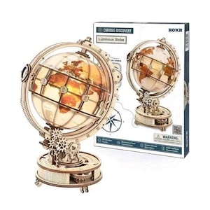 May include: A ROKR Curious Discovery Luminous Globe DIY wooden puzzle kit. The assembled globe features a light-up map with mechanical gears on a circular base. The packaging box displays the product name, brand logo, and assembly illustrations.
