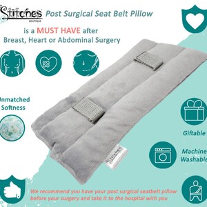 May include: A light gray post-surgical seat belt pillow with a soft, plush texture. The pillow has three padded sections and two silver-colored closures. The text on the pillow reads "Post Surgical Seat Belt Pillow" and "is a MUST HAVE after Breast, Heart or Abdominal Surgery."