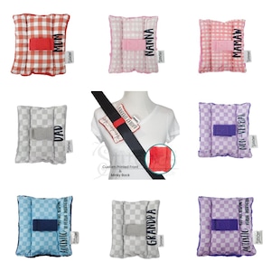 May include: A collection of soft, square seatbelt covers in various colors and patterns. Each cover features a different word, including "MOM," "DAD," "NANNA," "MAMAW," "GRANDPA," "NON-VERBAL," and "AUTISTIC." The covers have a custom printed front and a minky back.
