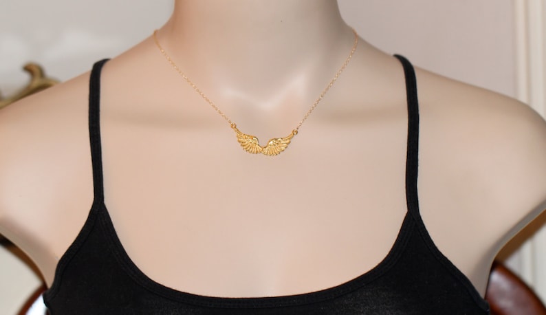 Peut inclure: Un collier en cha&icirc;ne dor&eacute;e avec un pendentif d&eacute;licat en forme d'aile d'ange.