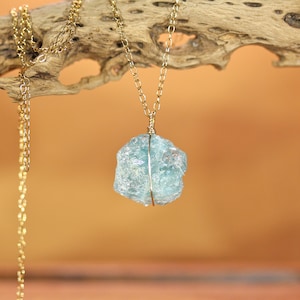 Collana con acquamarina grezza, catena in oro 14 carati, pietra portafortuna di marzo.