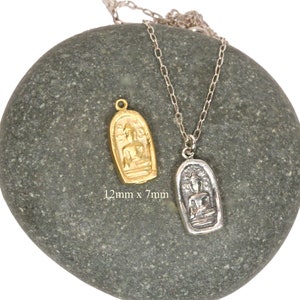 May include: Two silver necklaces with pendants featuring a seated Buddha figure. The pendant on the left is gold and the pendant on the right is silver. The pendants are 12mm x 7mm.