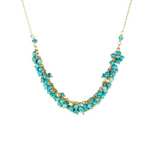 May include: A gold chain necklace with turquoise beads. The beads are clustered together in a cascading design.
