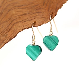 Peut inclure: Une paire de boucles d'oreilles en or en forme de c&oelig;ur avec des pierres de malachite vertes.