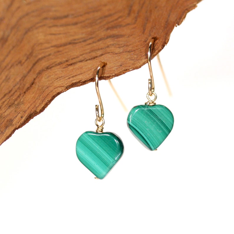 Peut inclure: Une paire de boucles d'oreilles en or en forme de c&oelig;ur avec des pierres de malachite vertes.