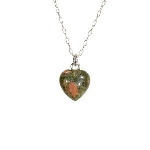 May include: A silver chain necklace with a green and pink heart-shaped pendant.