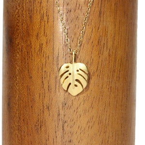 Peut inclure: Un collier en or avec une cha&icirc;ne d&eacute;licate et un pendentif en forme de feuille de monstera.