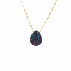 May include: A gold chain necklace with a teardrop-shaped black opal pendant. The opal has iridescent green, blue, and red flashes.