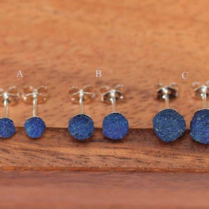 May include: Three pairs of silver stud earrings with blue azurite stones. The stones are different sizes, with the smallest pair labeled 'A', the medium pair labeled 'B', and the largest pair labeled 'C'.