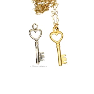 Puede incluir: Dos collares de oro con llaves en forma de coraz&oacute;n. Las llaves miden 16 mm x 6 mm.