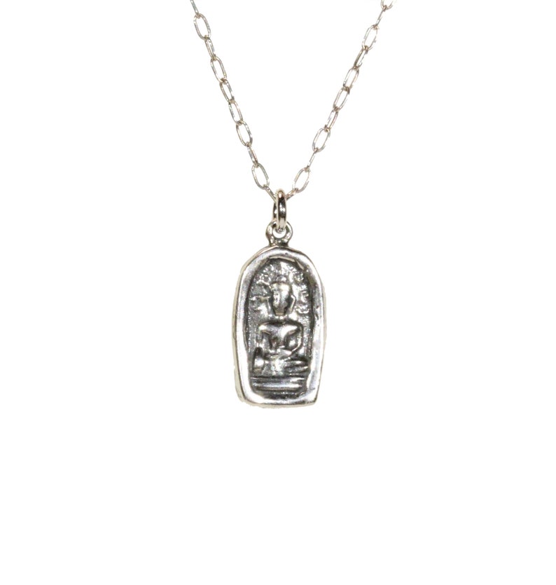 May include: A silver chain necklace with a pendant featuring a small, detailed image of a seated Buddha figure.