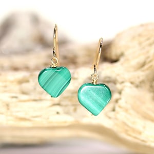 Peut inclure: Une paire de boucles d'oreilles en or en forme de c&oelig;ur avec des pierres de malachite vertes.