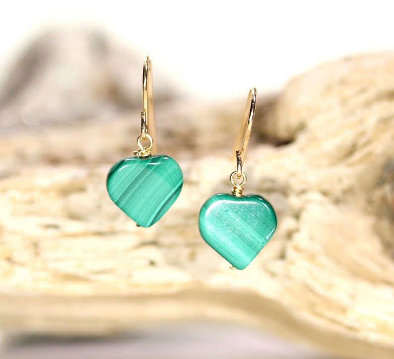 Peut inclure: Une paire de boucles d'oreilles en or en forme de c&oelig;ur avec des pierres de malachite vertes.
