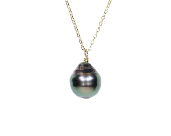 Può includere: Una collana con catena dorata con un ciondolo di grande perla barocca verde scuro.