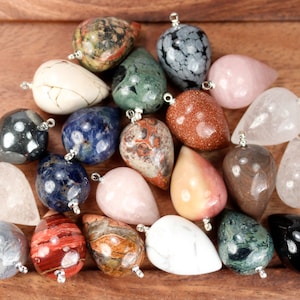 May include: Assortment of 20 gemstone pendants in various colors and patterns, including clear, white, black, brown, red, pink, blue, green, and gray. Each pendant is shaped like a teardrop and has a silver bail.