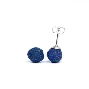May include: A pair of silver stud earrings with blue azurite stone spheres.