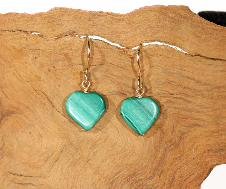 Peut inclure: Une paire de boucles d'oreilles en forme de c&oelig;ur en or avec des pierres de malachite vertes.