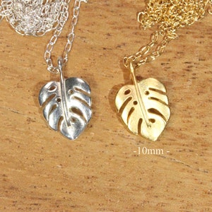 Peut inclure: Deux colliers en argent et en or avec un pendentif en forme de feuille de monstera. La feuille est d&eacute;coup&eacute;e et pr&eacute;sente un design d&eacute;licat. Les colliers mesurent 10 mm de long.