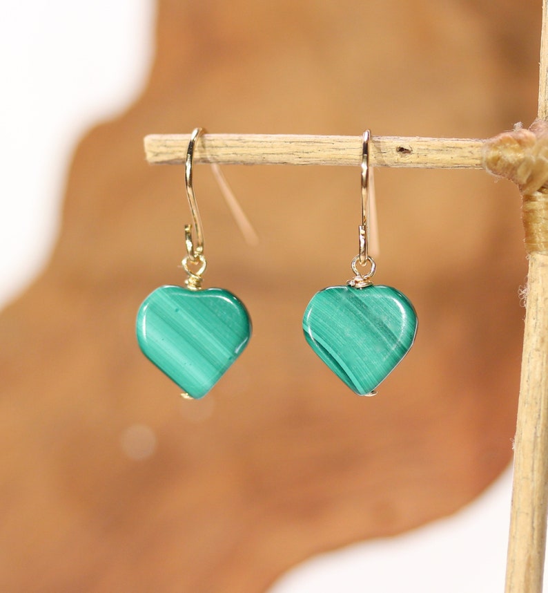 Peut inclure: Une paire de boucles d'oreilles en or en forme de c&oelig;ur avec des pierres de malachite vertes.