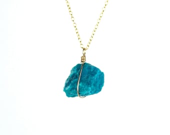 May include: A gold chain necklace with a raw turquoise stone pendant.