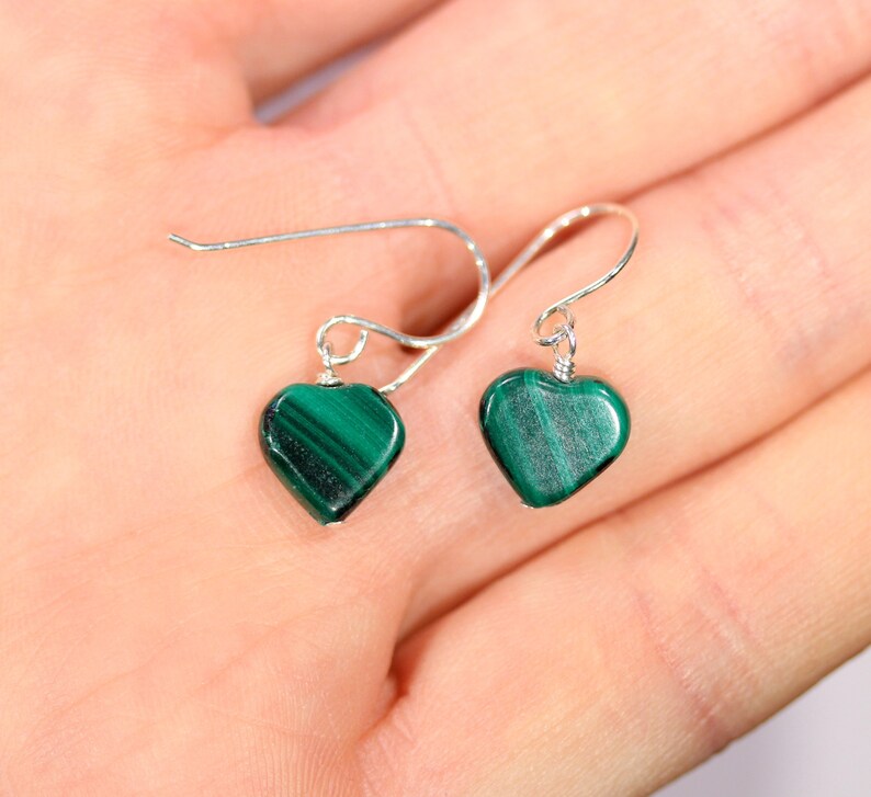 Peut inclure: Une paire de boucles d'oreilles en argent en forme de c&oelig;ur avec des pierres de malachite vertes.