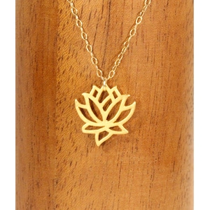 May include: A gold-toned necklace with a delicate lotus flower pendant. The pendant is a cutout design, creating a delicate and intricate look.