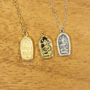 May include: Three gold and silver necklaces with pendants featuring a Buddha figure. The pendants are rectangular and have a matte finish.